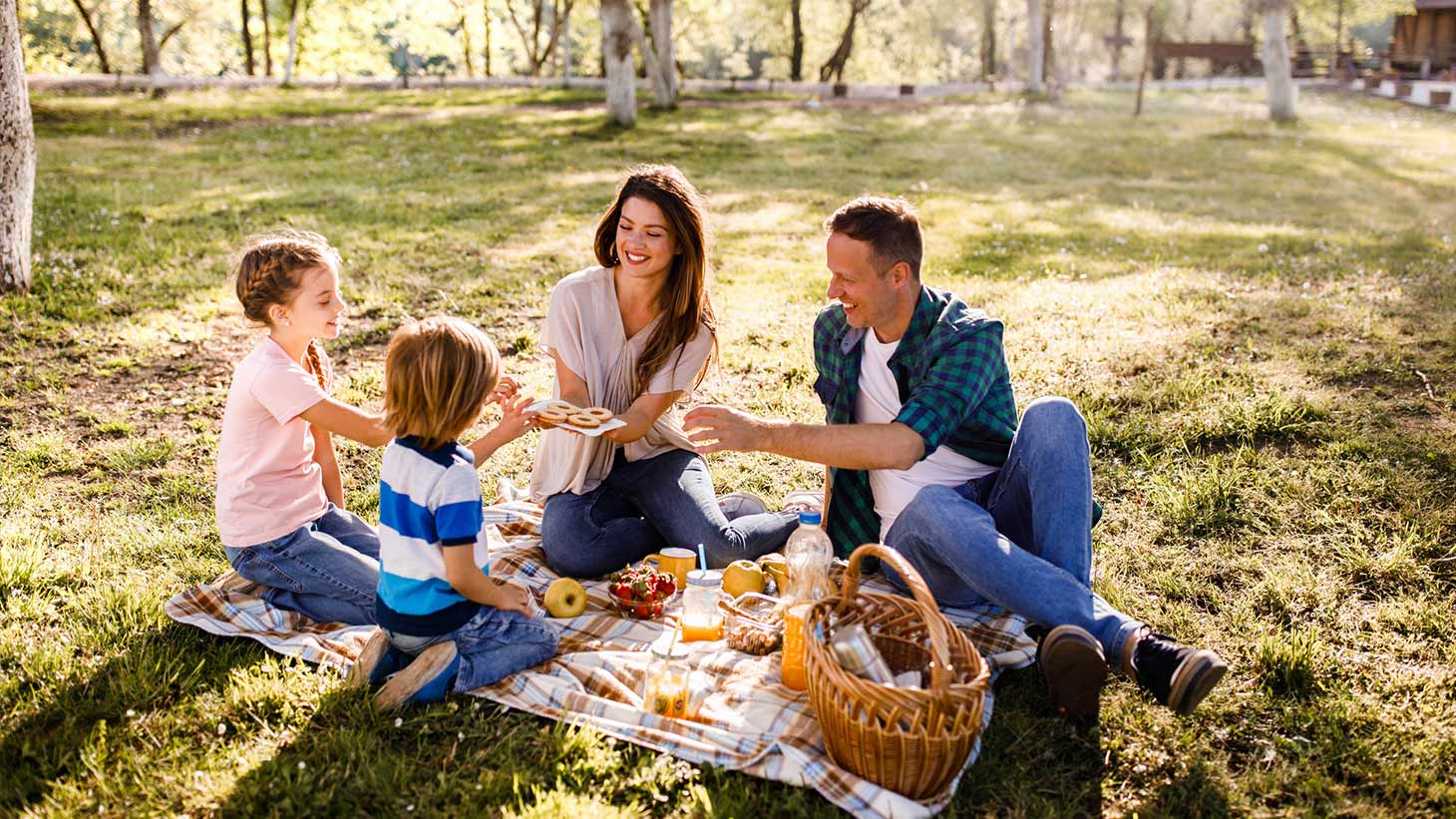 Una pareja y sus dos hijos pequeños comparten un pícnic